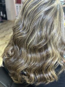 Glossy balayage highlights on long wavy hair styled at Sanaa Ahmed beauty salon serving clients from Fifth Settlement near 5A Waterway Cairo Festival City Nasr City