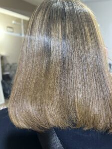 Smooth straight shoulder-length hair with natural shine after hair treatment at salon in New Cairo