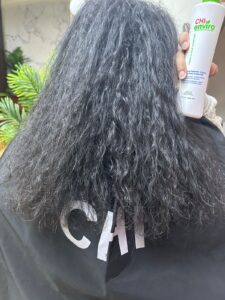 Before result of CHI Enviro hair treatment at Sanaa Ahmed Beauty Salon in New Cairo showing frizzy, textured hair before smoothing service at a women’s hair salon