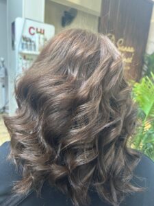Styled wavy hair transformation at a beauty salon in New Cairo with soft curls and volume, completed by Sanaa Ahmed Beauty Salon for clients seeking elegant hair styling, blow dry and finishing services for events and daily looks
