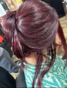Deep burgundy hair color styled in a sleek finish at a beauty salon in New Cairo, showing vibrant tones, smooth texture, and detailed color application.