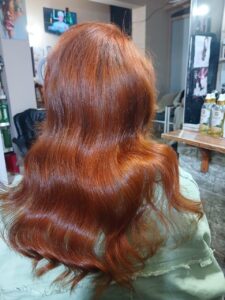 Warm copper hair color with soft waves done at a beauty salon in New Cairo, highlighting rich tones, natural movement, and a healthy shine.